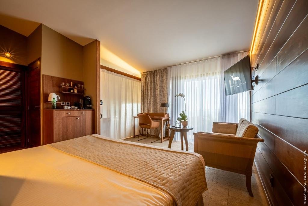 Chambre élégante et lumineuse du Diana Dea Lodge, hôtel 5 étoiles à La Réunion, avec grand lit et espace salon