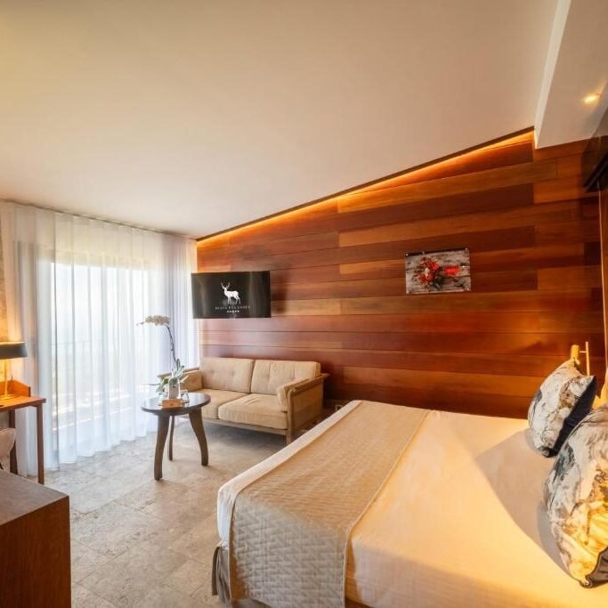 Chambre élégante avec mur en bois et lit king size au Diana Dea Lodge, hôtel 5 étoiles à La Réunion